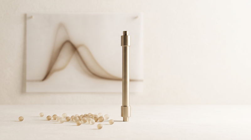 Abstract still life of a chromatography column and glass silica beads in warm gold and ivory studio light